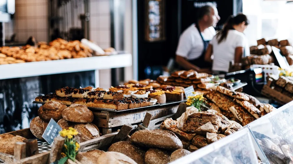 Stimmungsbild zum Beitrag: Es wird eine Backauslage in einer Bäckerei abgebildet.